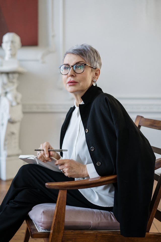 Illustrative image Woman in Black Blazer Sitting on Brown Wooden Chair used in Accordemy®'s training on Effective Workplace Counselling