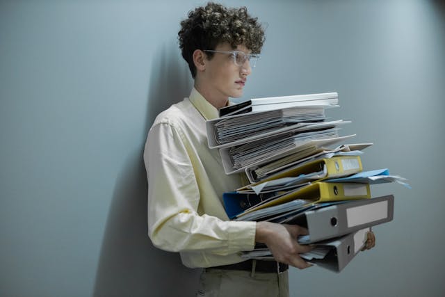 Illustrative image Man Holding Pile of Documents used in Accordemy®'s training on Employee Rights and Responsibilities