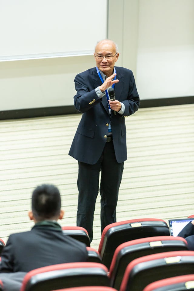 Illustrative image Man Standing in Front of Chairs and People
 used in Accordemy®'s training on SBM for Training Programs