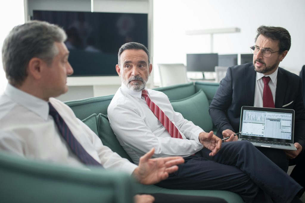  Illustrative image of Men Sitting on Sofa at the Office While Having a Conversation  used in Accordemy®'s training on Non-Verbal Communication for Executives