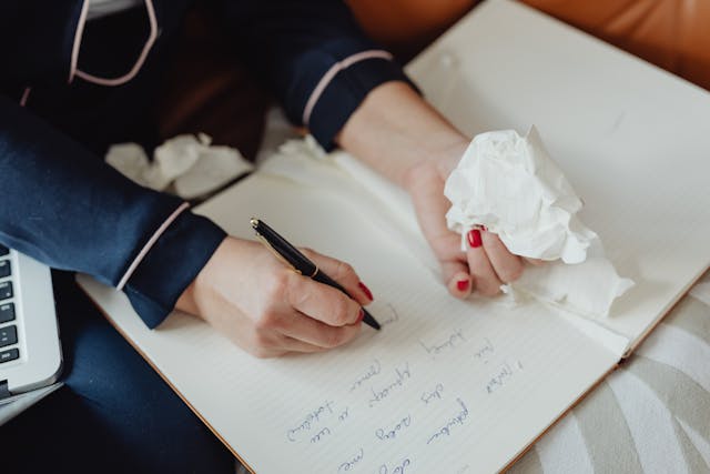 Illustrative image Person with Red Nails Writing on a Notebook
used in Accordemy®'s training on Personal Development Planning