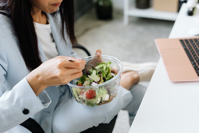 Illustrative image Person Wearing Blazer Eating Vegetable Salad used in Accordemy®'s training on Health and Wellness at Work