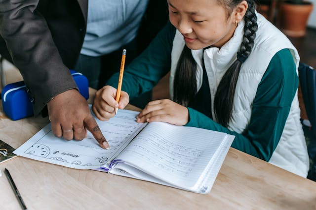 Illustrative image Crop ethnic schoolgirl with teacher during class used in Accordemy®'s training on Performance Quality Improvement
