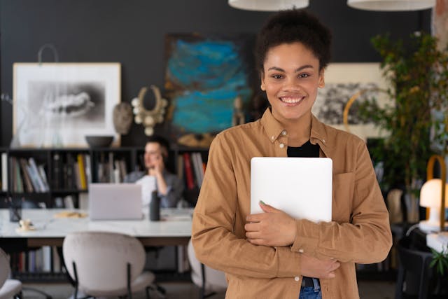 Illustrative image A Woman Smiling While Holding a Laptop used in Accordemy®'s training on Employee Benefits and Pensions Management