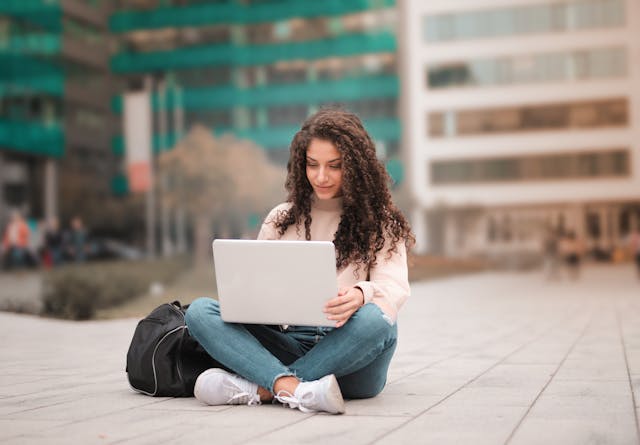 Illustrative image Woman in Pink Sweater Using Laptop  used in Accordemy®'s training on Millennial Onboarding