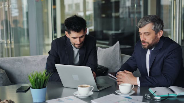 Illustrative image A man in a suit reading a book used in Accordemy®'s training on Developing a Lunch and Learn