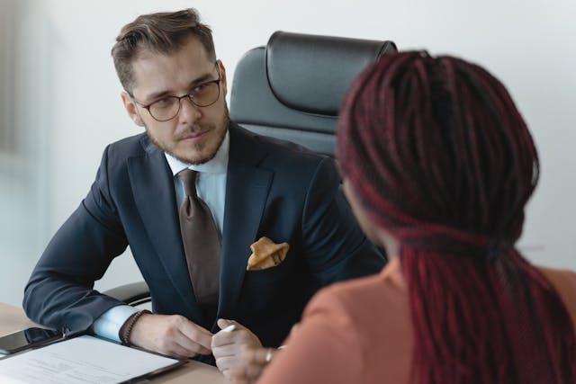 Illustrative image Man in Corporate Attire Sitting In front of a Person with Afro Braids used in Accordemy®'s training on HR Leadership and Change Management