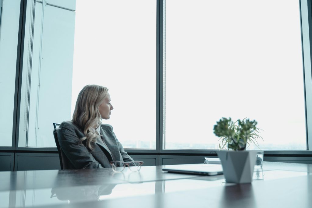 Illustrative image of A Woman in Black Leather Jacket Sitting by the Table used in Accordemy®'s training onLeadership Styles that suit a manager.
