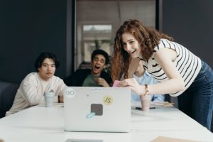 Illustrative image People Laughing Looking at a Laptop used in Accordemy®'s training on Scrum and Agile Project Management
