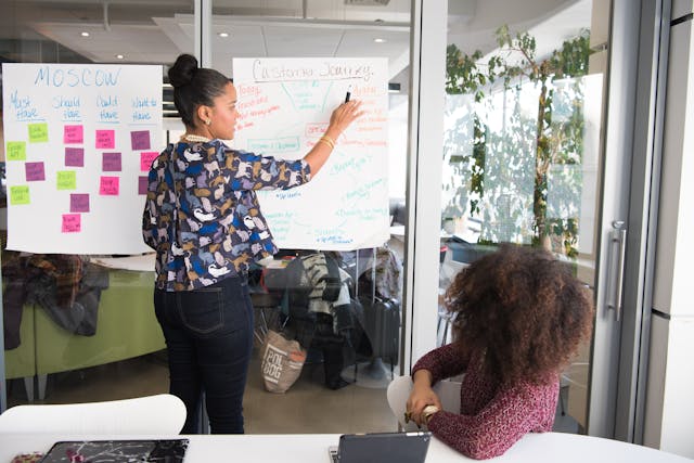 Illustrative image Two Women Having a Meeting Inside Glass-panel Office used in Accordemy®'s training on Agile Project Management in Land Affairs