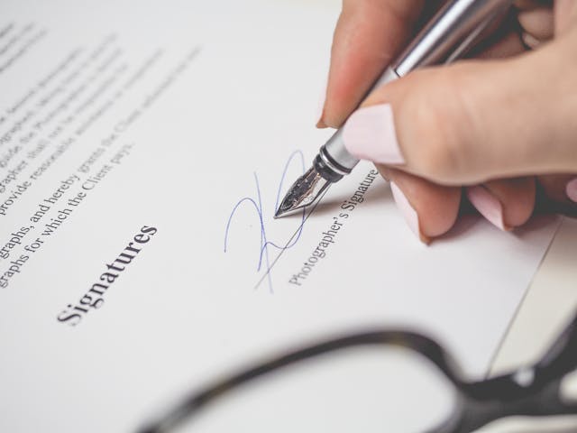 Illustrative image Person Signing a Contract used in Accordemy®'s training on Contract Negotiation and Dispute Resolution