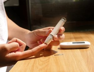 Illustrative image A person is using a digital thermometer to check their blood sugar used in Accordemy®'s training on Successful Health Awareness Programming