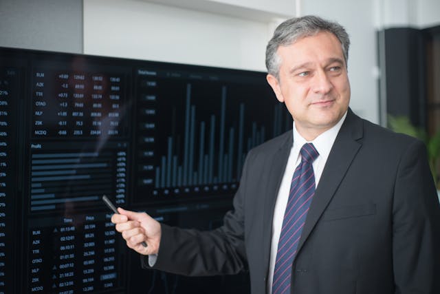 Illustrative image Man Wearing a Black Suit Holding a Pen used in Accordemy®'s training on Forecasting and Demand Planning