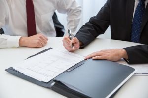Illustrative image A Person in Black Suit Holding a Pen used in Accordemy®'s training on Outsourcing and Contract Management