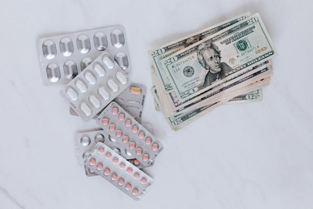 Illustrative image Set of pills with heap of paper money used in Accordemy®'s training on Health Finance and Health Insurance Systems