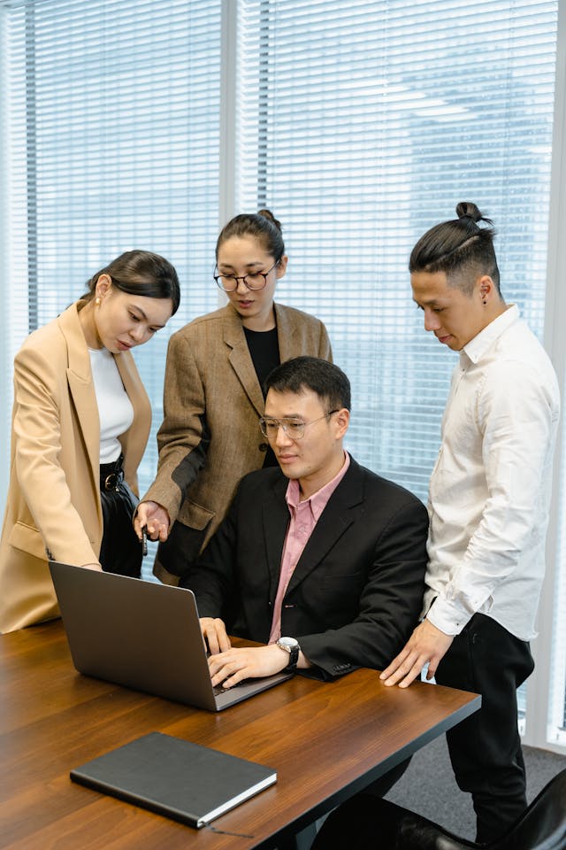 Illustrative image Colleagues Looking at a Laptop used in Accordemy®'s training on Supervisory skills for project managers