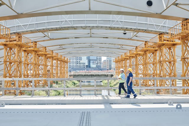 Illustrative image Construction Workers Walking Near Metal Railings used in Accordemy®'s training on Humanitarian and International Development