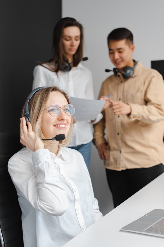 Illustrative image Woman in a White Shirt Smiling while Holding Her Headset used in Accordemy®'s training on Import-Export Operations