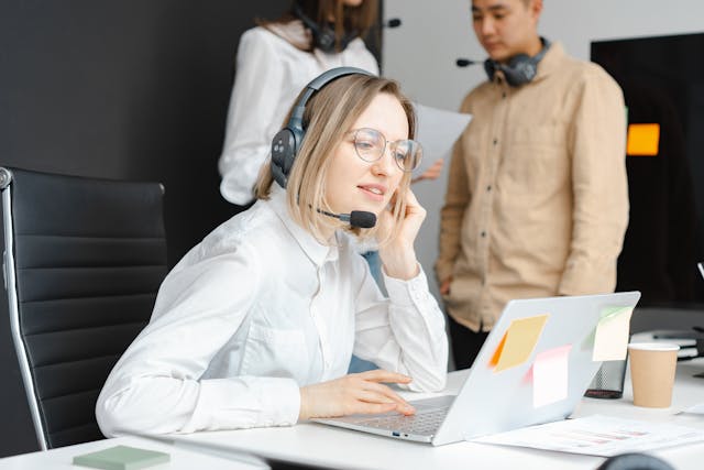Illustrative image Woman with a Black Headset Working on Her Laptop used in Accordemy®'s training on Import-Export Operations