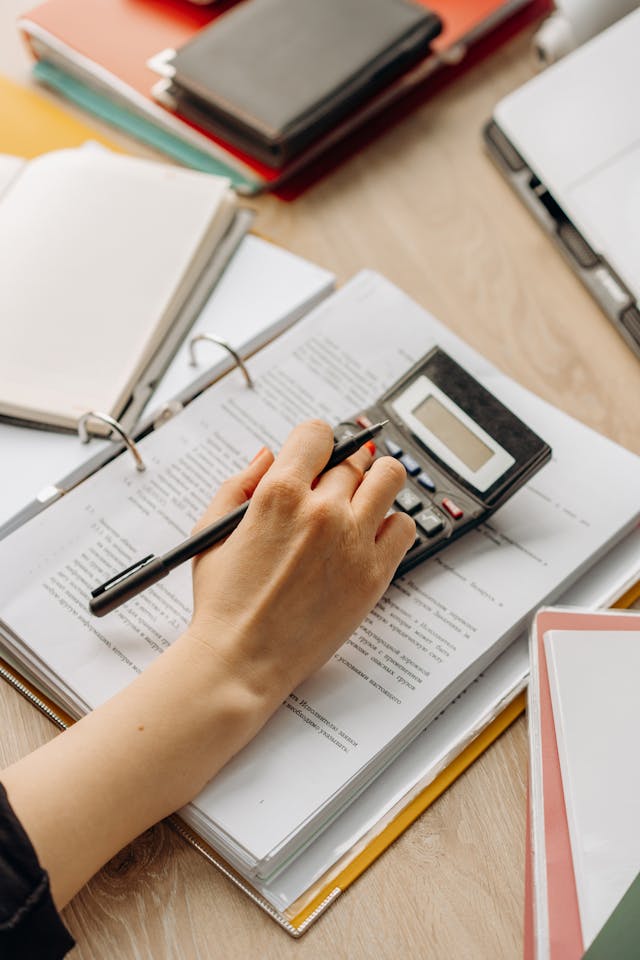 Illustrative image A Person using Calculator used in Accordemy®'s training on Project Scheduling and Budgeting