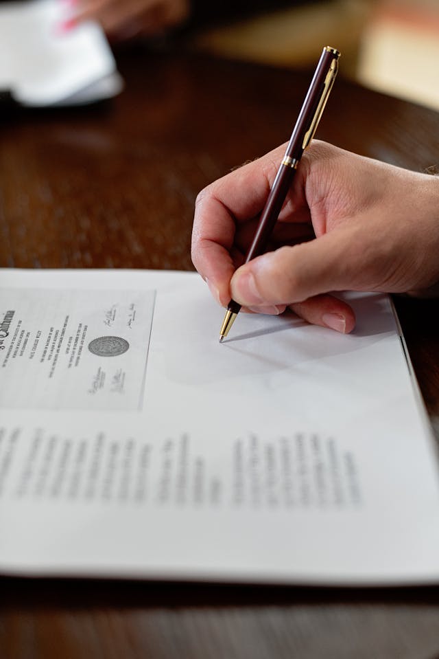 Illustrative image A Close-Up Shot of a Person Signing a Document used in Accordemy®'s training on International Contract Law