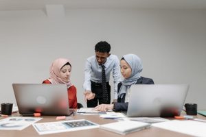 Illustrative image Woman in Red Long Sleeve Shirt Sitting beside Woman in Gray Blazer used in Accordemy®'s training on Supervision Skills for Managers in Land/Portfolio Management