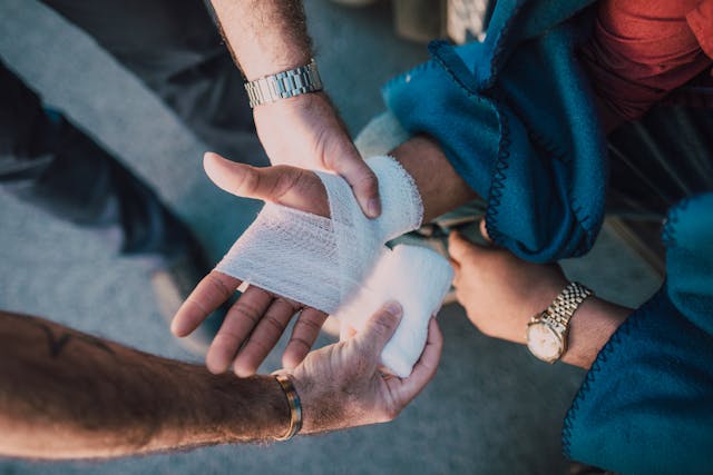 Illustrative image Person Applying Bandage on Another Person's Hand used in Accordemy®'s training on Healthcare Management in Humanitarian Emergencies