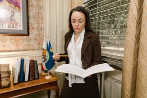 Illustrative image Woman in Brown Blazer Holding a Document used in Accordemy®'s training on Government Contract Management