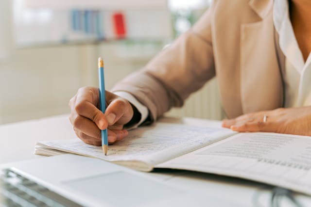 Illustrative image Person in White Top Writing on Notebook used in Accordemy®'s training on Tendering Processes