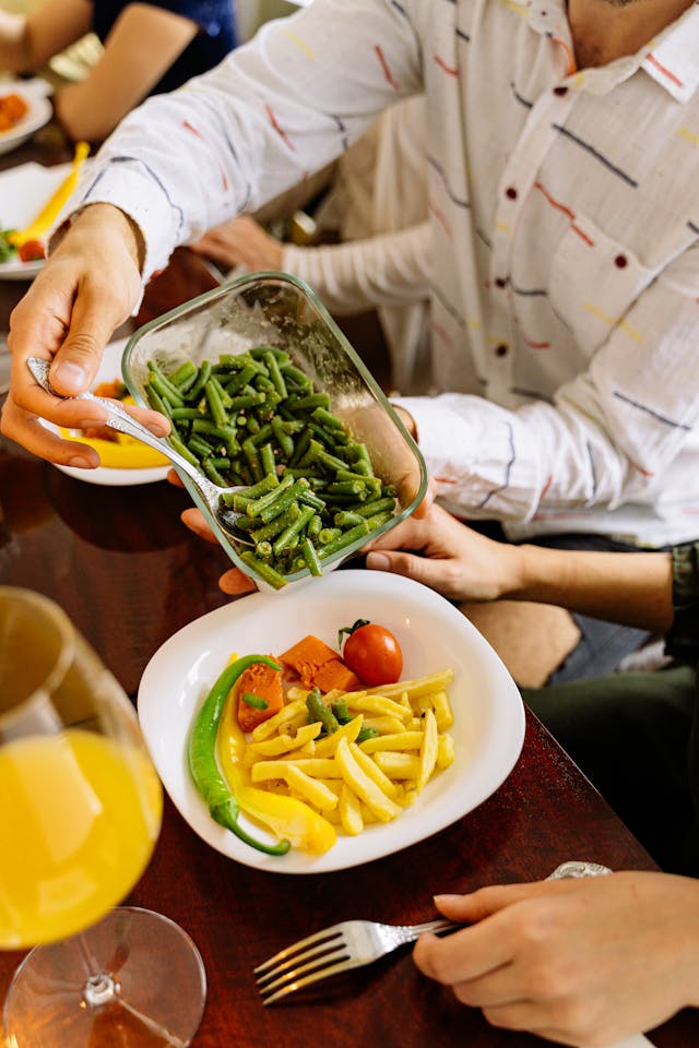 Illustrative image A Person Scooping Slices of Green Vegetable from a Container used in Accordemy®'s training on Advanced Nutrition and Dietetics