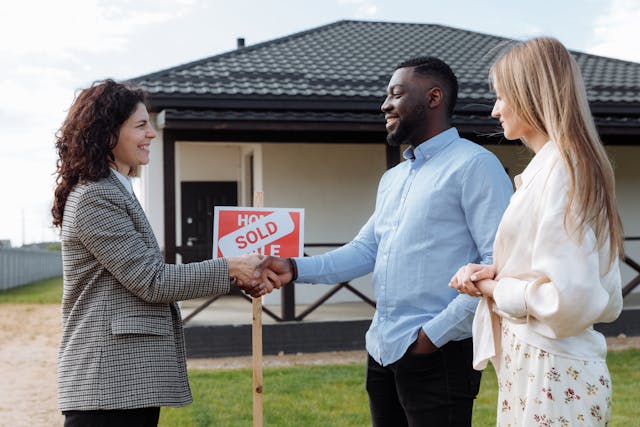Illustrative image A Woman in Gray Blazer Standing on Green Grass Near the House used in Accordemy®'s training on Managing Multiple Land Affair Projects