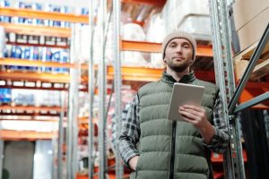 Illustrative image Man in Black Bubble Jacket Holding White Tablet Computer used in Accordemy®'s training on Lean Logistics Implementation