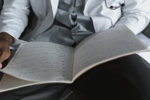 Illustrative image Person in White Dress Shirt Reading Book used in Accordemy®'s training on Report Writing Skills for Healthcare Workers