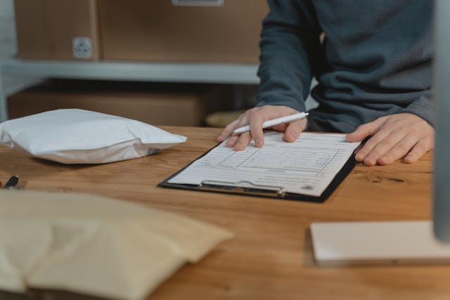 Illustrative image A Person Filling up a Form on a Clipboard used in Accordemy®'s training on International Logistics Management