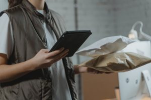 Illustrative image used Woman Holding Black Tablet Computer in Accordemy®'s training on Reverse Logistics and Returns Management