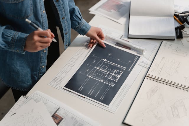 Illustrative image Person in Blue Denim Jacket Holding White Printer Paper used in Accordemy®'s training on Project Management in Logistics