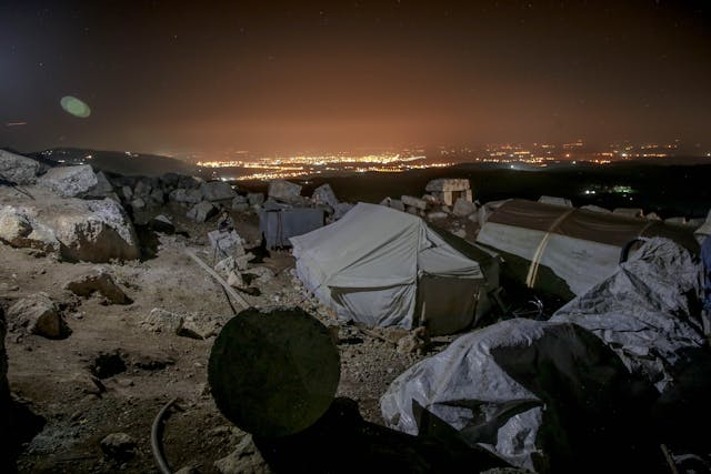 Illustrative image Tents for homeless people in stony terrain at night used in Accordemy®'s training on Refugee and Displacement Issues