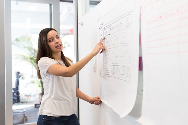 Illustrative image Photo Of Woman Pointing On White Paper used in Accordemy®'s training on The Why in Development Project Planning