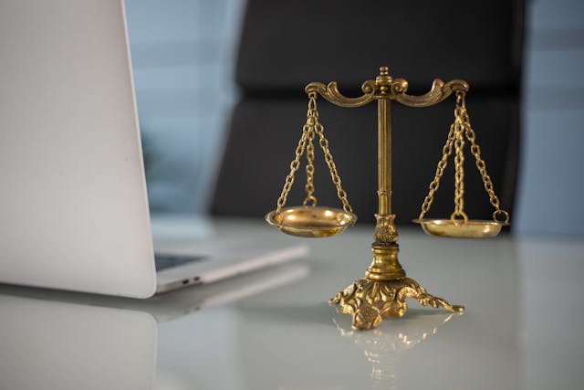 Illustrative image A Golden Balance Scale beside a Laptop used in Accordemy®'s training on Humanitarian Law and Ethics