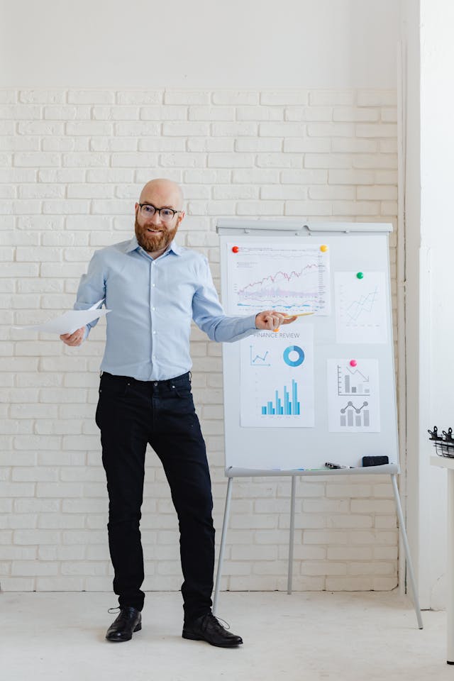 Illustrative image A Man Standing Beside a White Board with Posted Graphs and Charts used in Accordemy®'s training on Accordemy® Certified Trainer Level 3