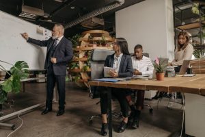 Illustrative image Group of People in a Business Meeting in an Office used in Accordemy®'s training on Effective Report Writing Skills for Relief and Development Managers