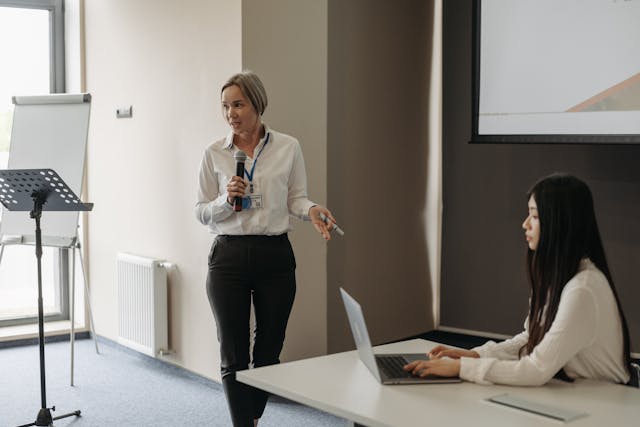 Illustrative image A Woman Talking on the Microphone used in Accordemy®'s training on Master Trainer