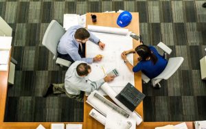 Illustrative image Three People Sitting Beside Table used in Accordemy®'s training on Advanced Project Management for Humanitarian Organizations