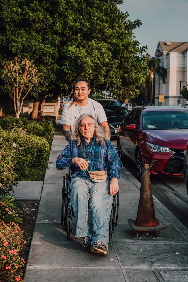 Illustrative image A Man Pushing an Elderly on a Wheelchair used in Accordemy®'s training on Humanitarian Diplomacy and Advocacy