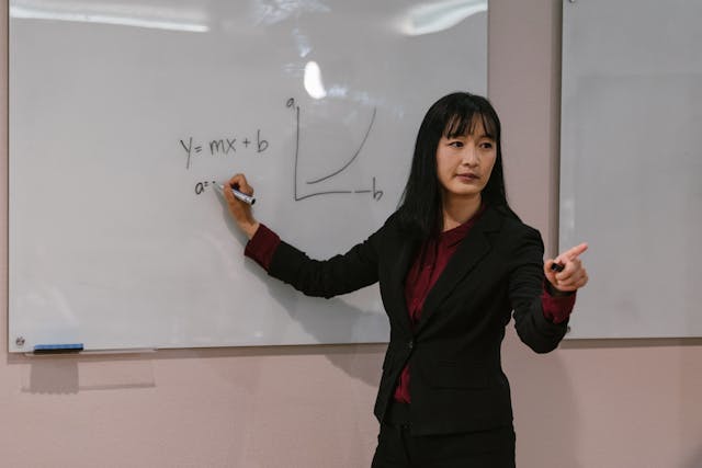 Illustrative image Female Professional writing on White Board  used in Accordemy®'s training on Essential ToT (Level 1): Foundational Training of Trainers Course