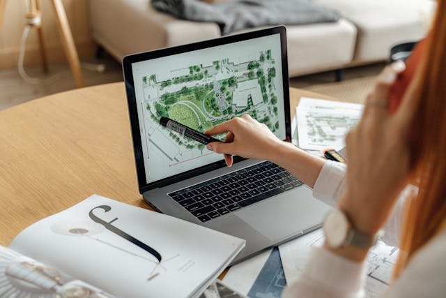 Illustrative image Person Writing on White Paper on Macbook Pro used in Accordemy®'s training on The Why in Development Project Planning