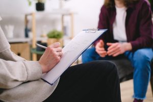 Illustrative image A Therapist Writing on a Paper used in Accordemy®'s training on Records Retention and Disposal
