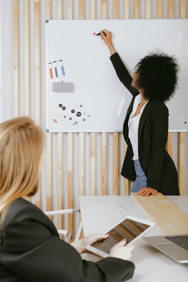 Illustrative image Woman Writing on Whiteboard used in Accordemy®'s training on Master Trainer