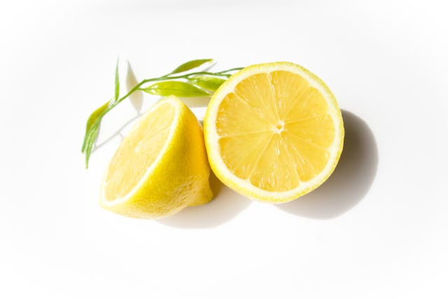 Illustrative image Fresh Sliced Lemon with Green Leaf on White Background used in Accordemy®'s training on Nutrition in Emergencies