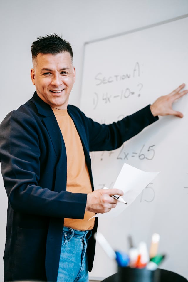 Illustrative image Photo Of Man Discussing On White Board used in Accordemy®'s training on Essential ToT (Level 1): Foundational Training of Trainers Course